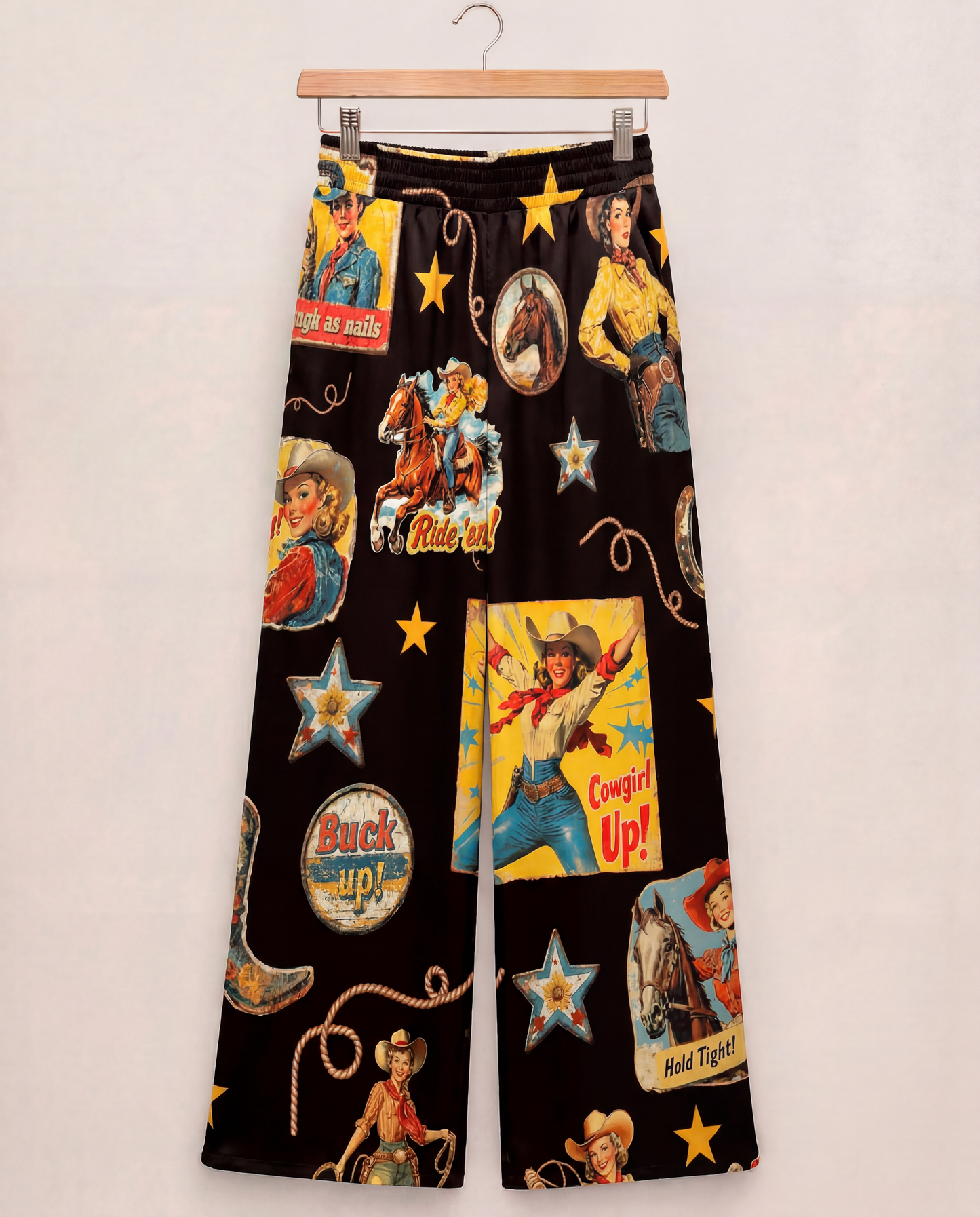 wide leg pants with colorful cowboy-themed graphics on a black background