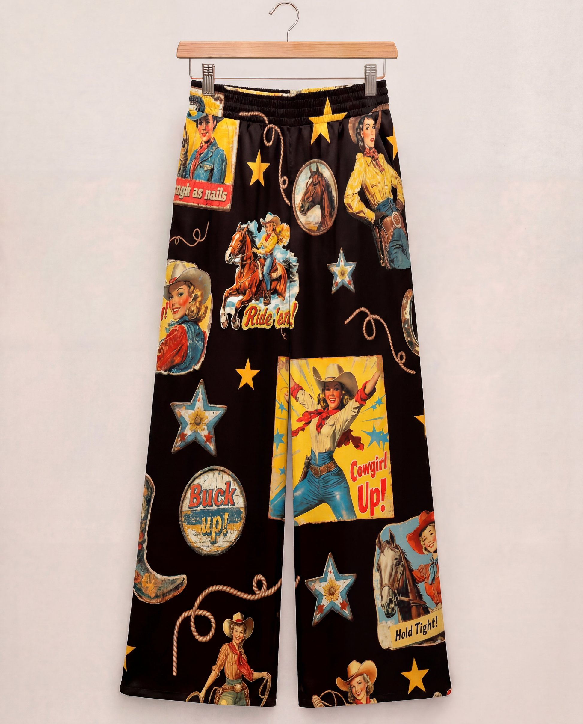 wide leg pants with colorful cowboy-themed graphics on a black background