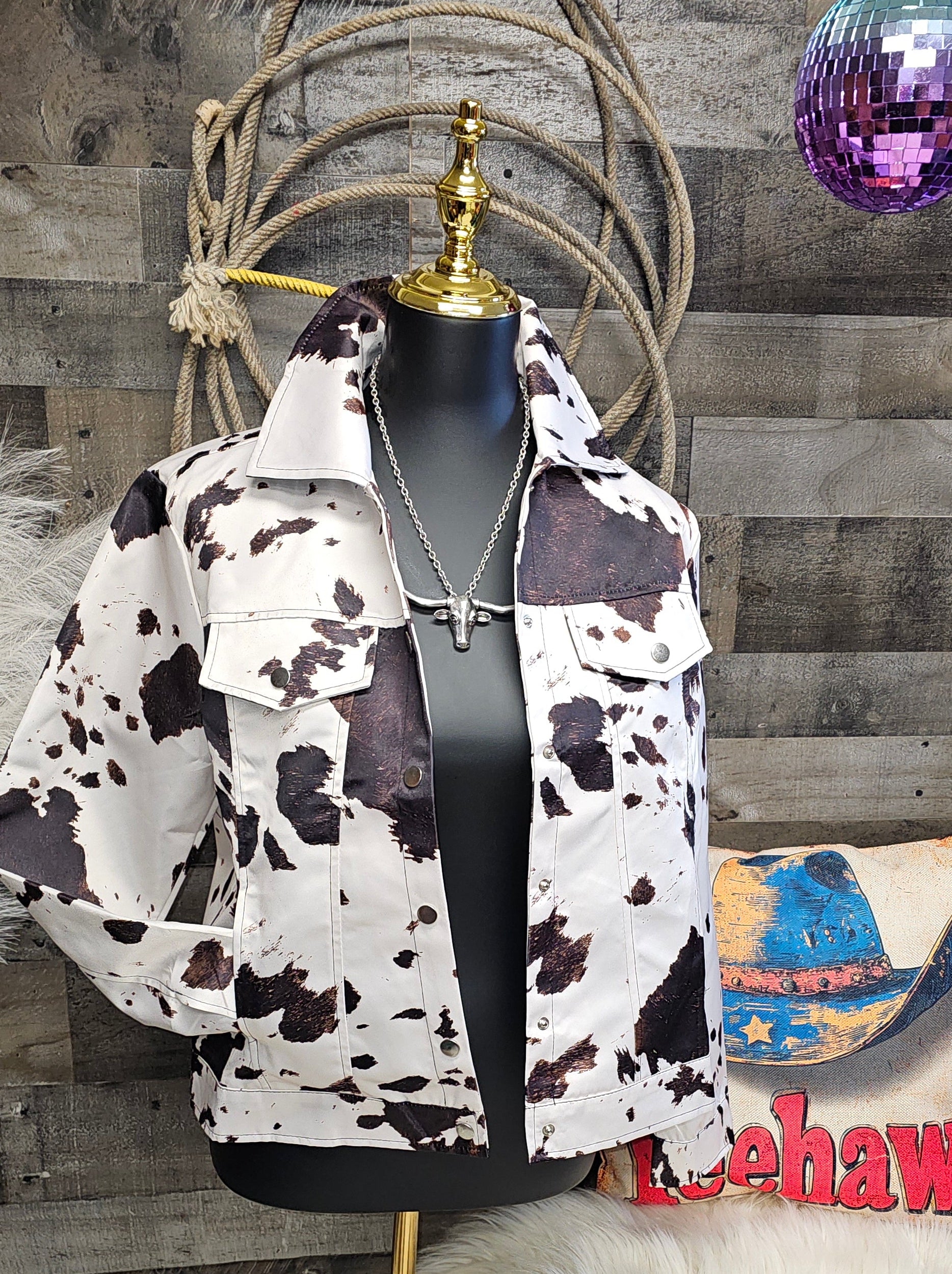 Cow print jacket on a wooden floor with decorative elements