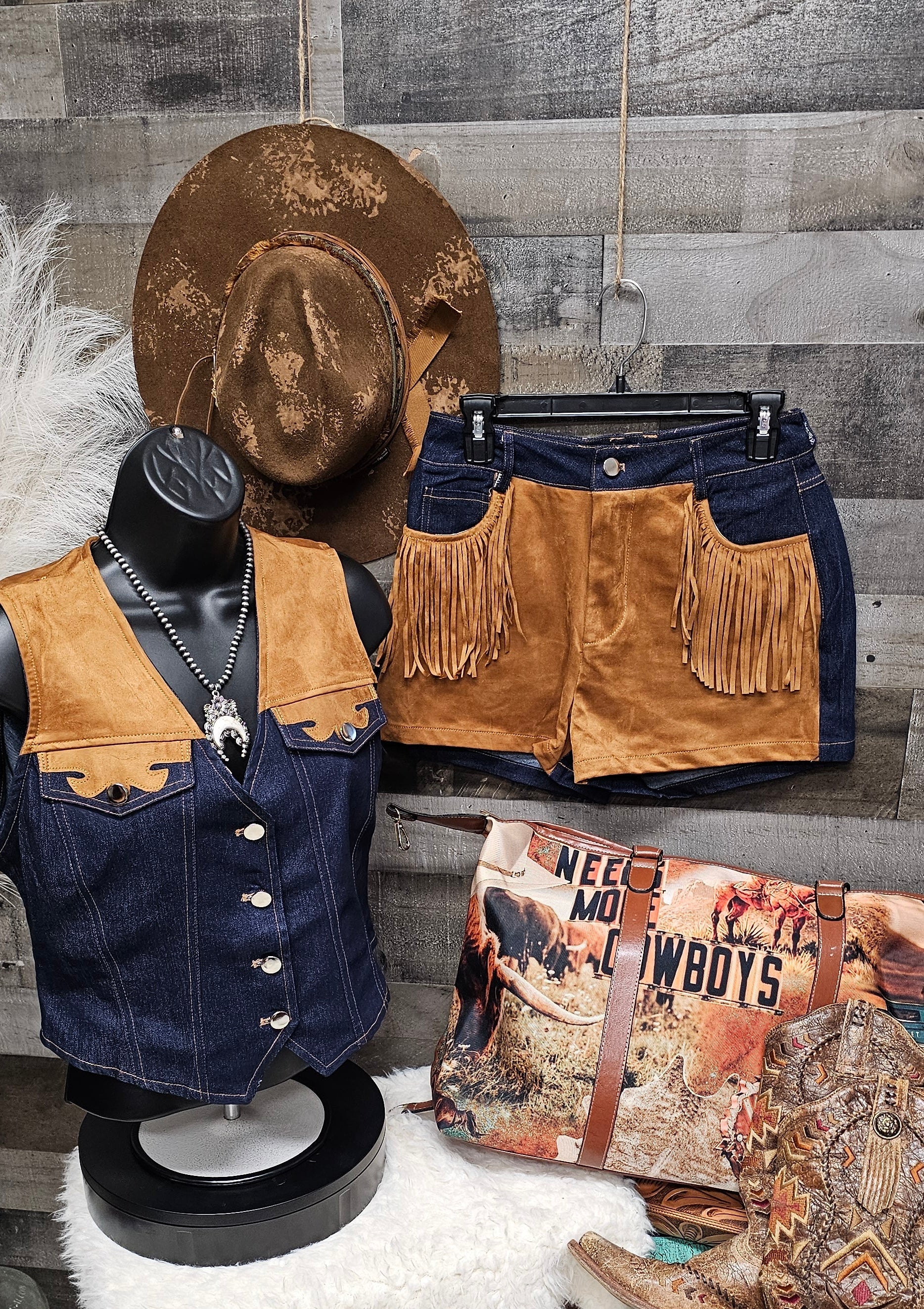 Collection of cowboy-themed items including hats, boots, and jackets on a textured surface.