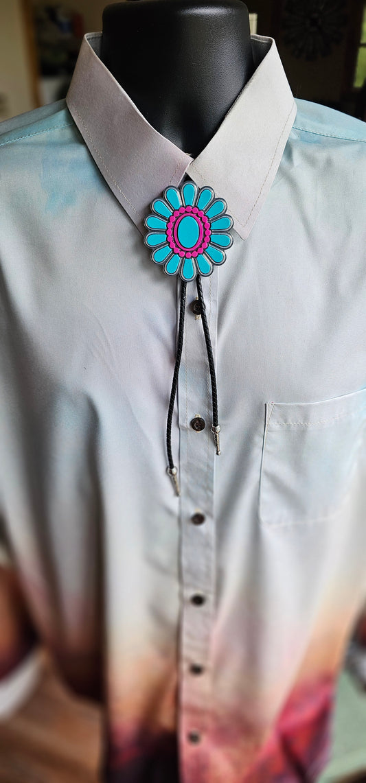 A turquoise and pink woven bolo tie necklace displayed on a mannequin wearing a light-colored collared shirt.
